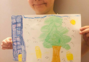 Chłopiec narysował swój blok i drzewo